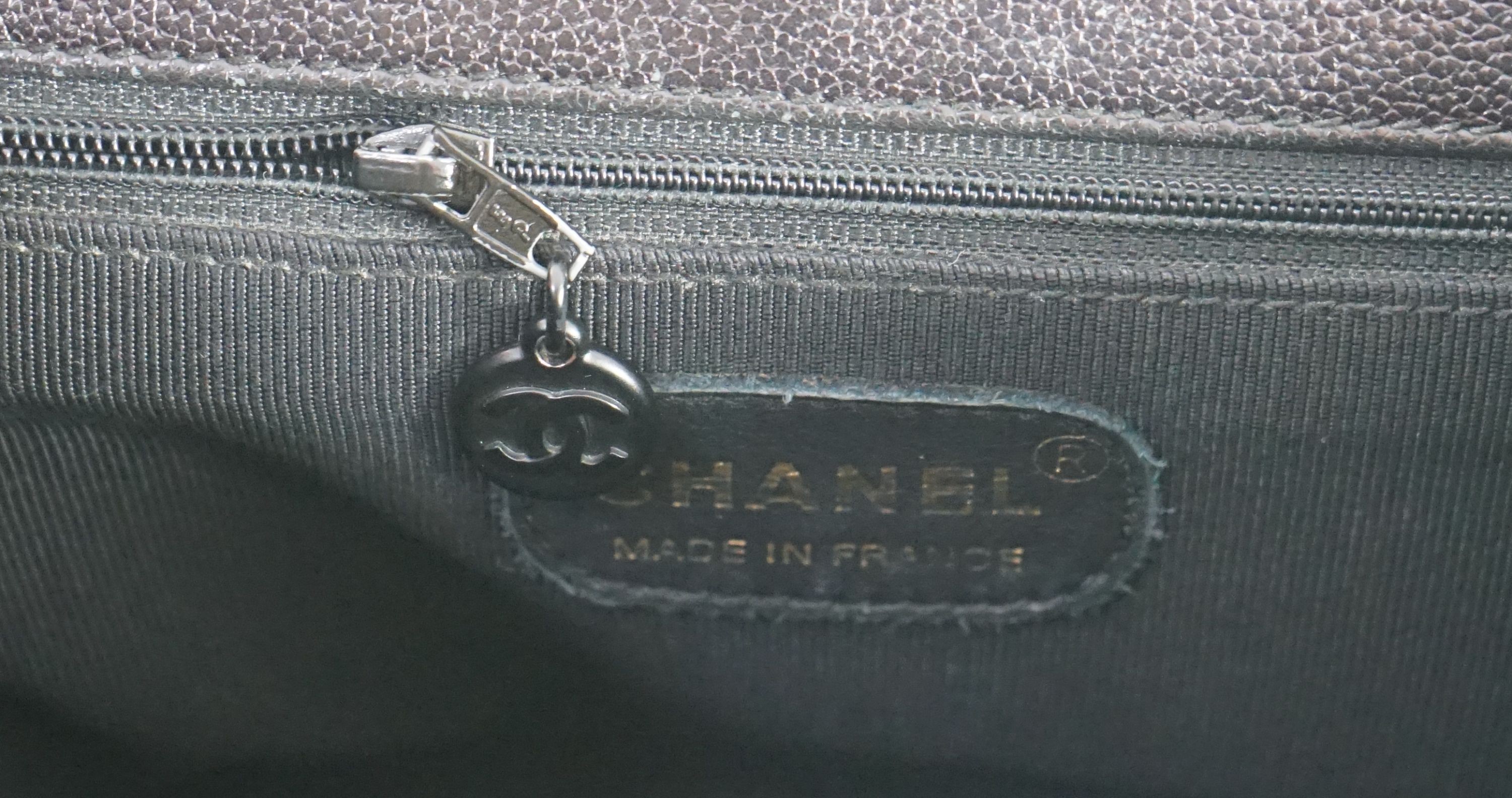 A black Chanel shoulder bag with two straps and Chanel logo lock